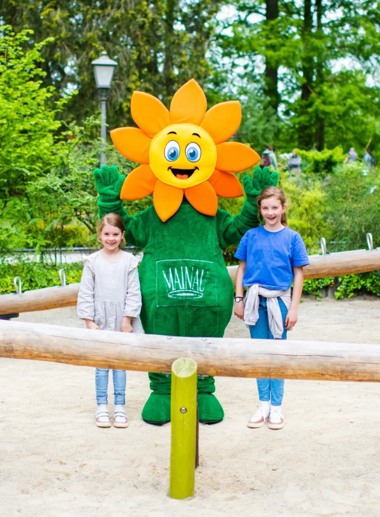 Unser Maskottchen Blumi auf der Insel Mainau mit zwei jungen Gästen