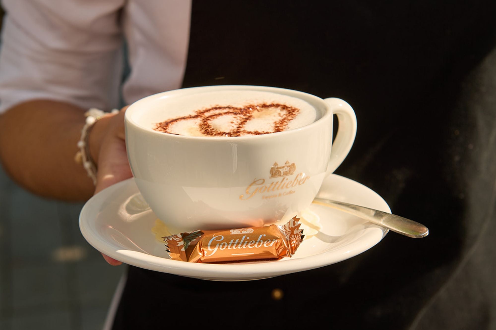 Gottlieber Kaffee Cappuccino in einer Tasse mit Gottlieber Mini Hüppen